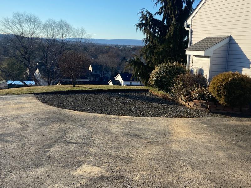 A faded gray asphalt driveway that is due for sealcoating