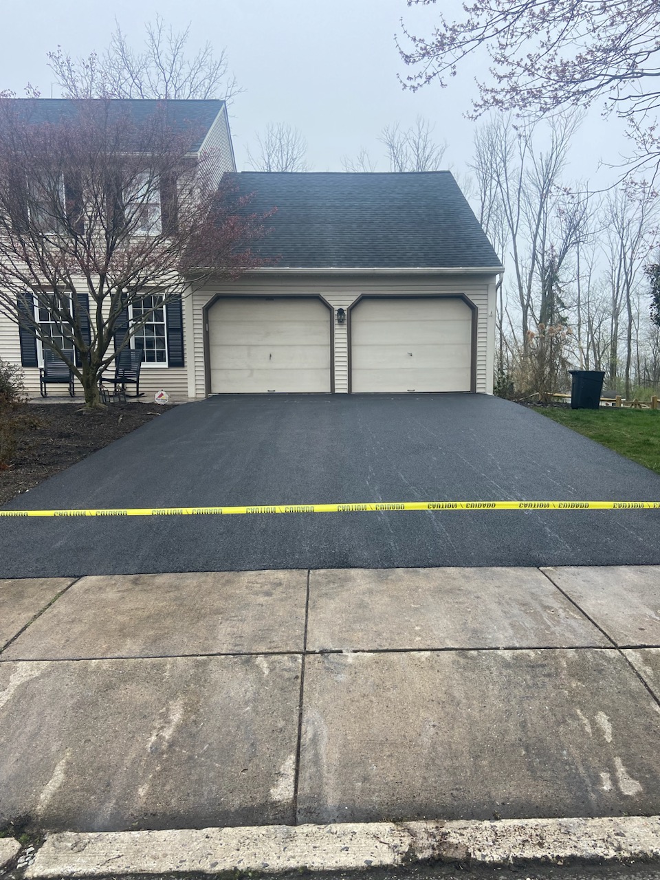 A freshly installed asphalt driveway curing behind caution tape in Berks County, PA