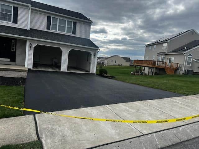 Newly replaced asphalt driveway at a two-story home by R. Stanley's Paving.